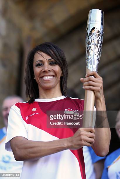In this handout image provided by Glasgow 2014 Ltd, Dame Kelly Holmes holds the Queen's Baton in front of Tonbridge Castle as the Glasgow 2014...