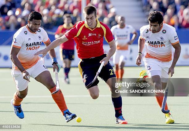 India's Raghunath Vokkaliga Ramachandra and Uthappa Sannuvanda Kushalappa vies for the ball with Spain's Alex Casasayas during the Field Hockey World...