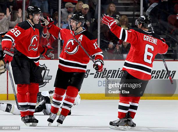 Jaromir Jagr of the New Jersey Devils is congratulated by teammates Travis Zajac and Andy Greene after Jagr scored an empty net goal in the third...