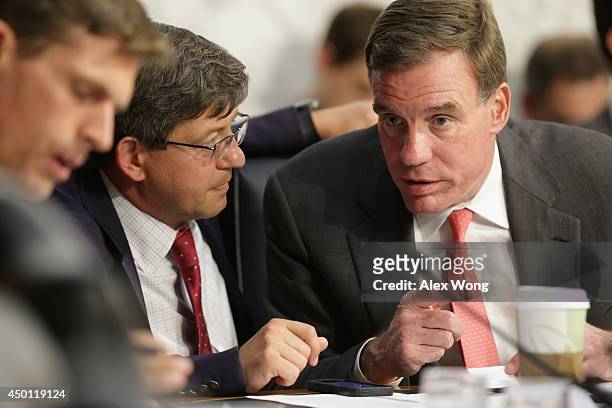 Sen. Mark Warner listens to an aide during a hearing before the Senate Intelligence Committee June 5, 2014 on Capitol Hill in Washington, DC. The...