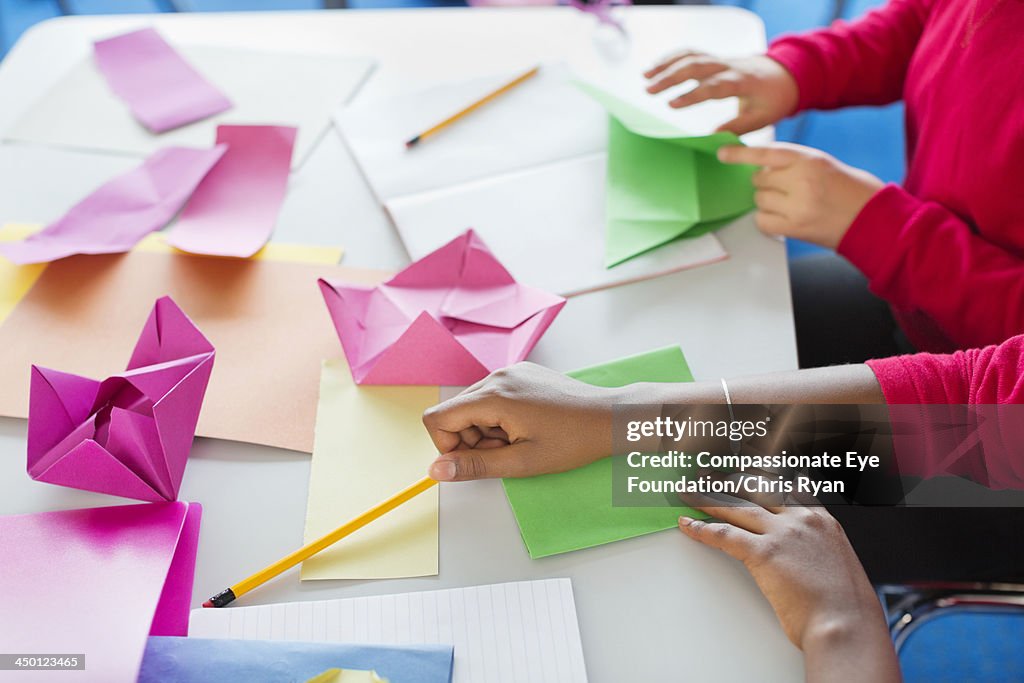 Students making origami in classroom