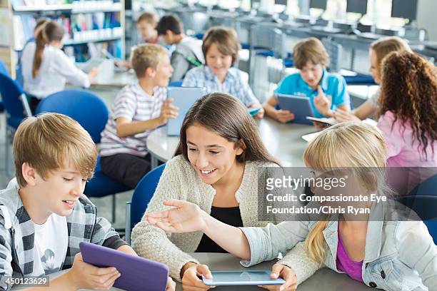 students using digital tablets in classroom - school boy girl foto e immagini stock