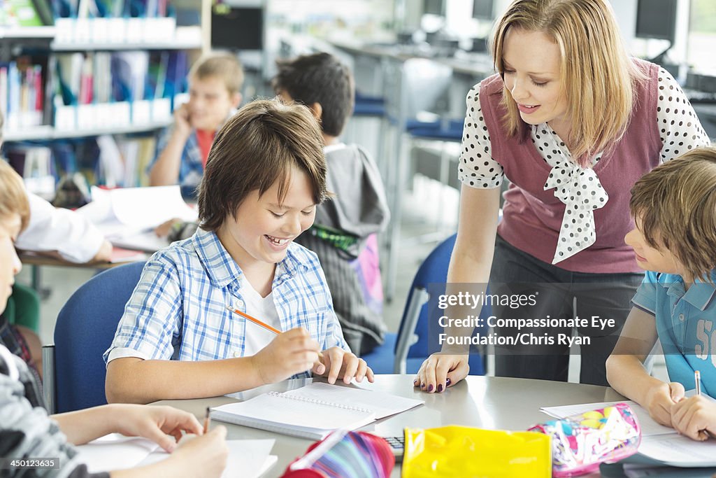 Teacher helping student with work in classroom
