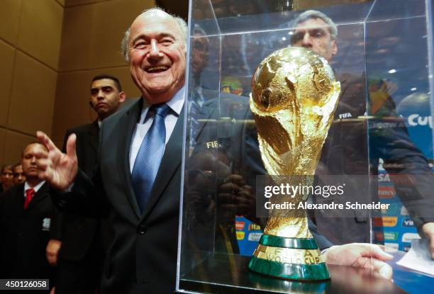 President of FIFA Joseph Blatter poses beside the copy of the trophy of the World Cup after the press conference following the last session of the...