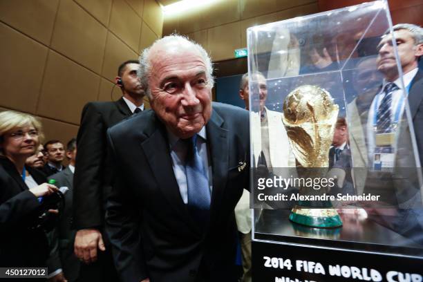 President of FIFA Joseph Blatter poses beside the World Cup trophy after a press conference following the last session of the Organising Committee...