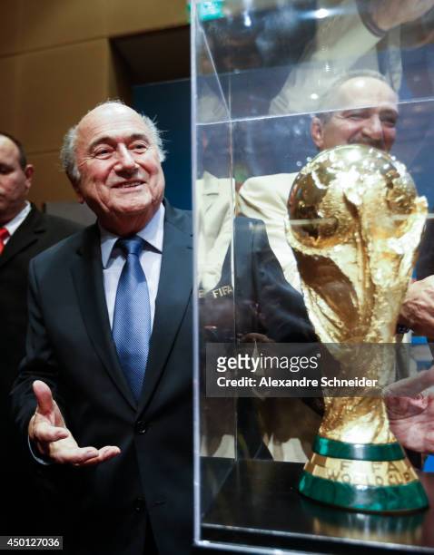 President of FIFA Joseph Blatter poses beside the World Cup trophy after a press conference following the last session of the Organising Committee...