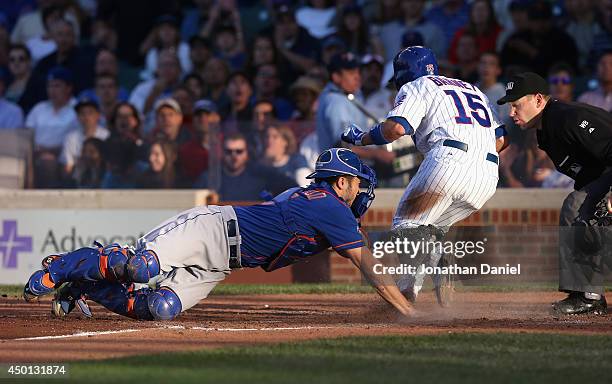 Darwin Barney of the Chicago Cubs gets past the tag attempt of Travis d'Arnaud 15 of the New York Mets to score a run in the 4th inning at Wrigley...