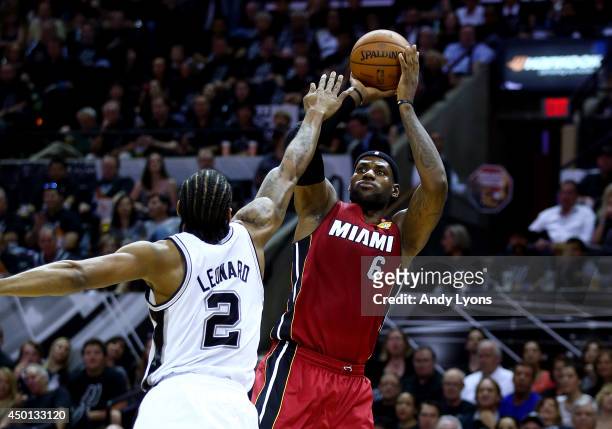 LeBron James of the Miami Heat takes a shot over Kawhi Leonard of the San Antonio Spurs during Game One of the 2014 NBA Finals at the AT&T Center on...