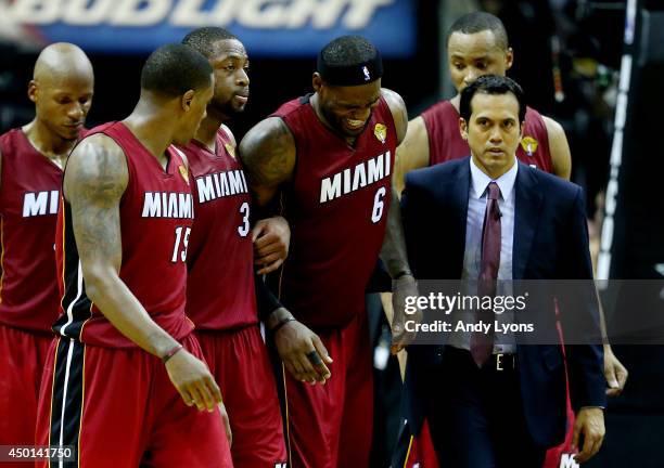 LeBron James of the Miami Heat is helped off the court after cramping up against the San Antonio Spurs during Game One of the 2014 NBA Finals at the...