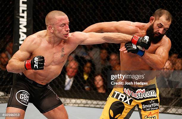 Georges St-Pierre punches Johny Hendricks in their UFC welterweight championship bout during the UFC 167 event inside the MGM Grand Garden Arena on...