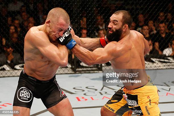 Johny Hendricks punches Georges St-Pierre in their UFC welterweight championship bout during the UFC 167 event inside the MGM Grand Garden Arena on...