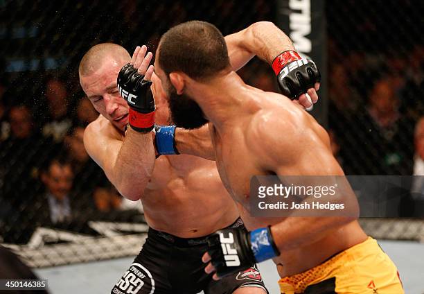 Johny Hendricks punches Georges St-Pierre in their UFC welterweight championship bout during the UFC 167 event inside the MGM Grand Garden Arena on...