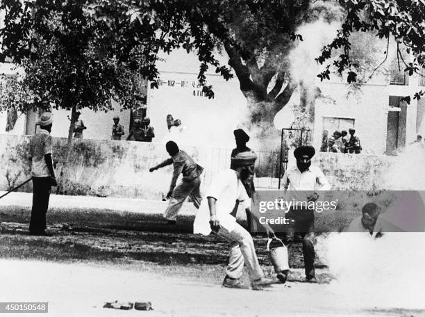 Sikhs militant throw a tear gas canister back at indian police after it was fired to breakup violence around the Gurdwara Bangla Sahib, also known as...