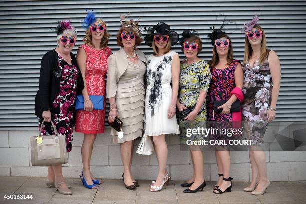 Racegoers pose for a photograph during Ladies Day at the Epsom Derby Festival, in Surrey, southern England, on June 6, 2014 AFP PHOTO / CARL COURT