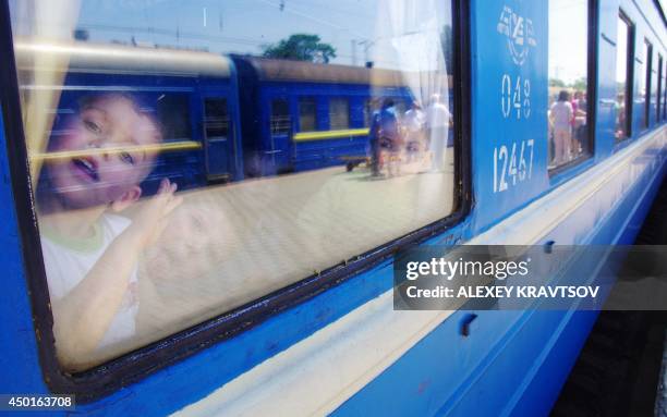 Boy looks out from a window of a train arriving from the eastern Ukrainian city of Lugansk in the southern Ukrainian city of Odessa on June 6, 2014....