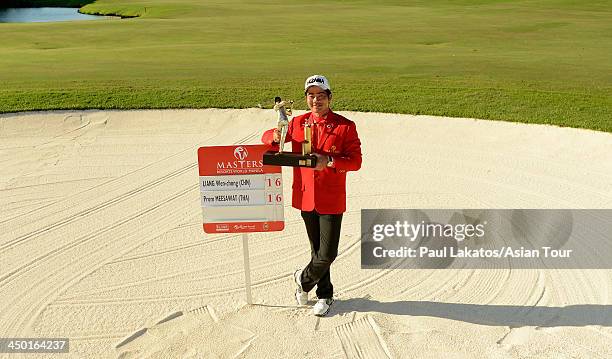 Liang Wen chong of China pictured with the winner's trophy after he defeated Prom Meesawat of Thailand in a playoff during round four of the Resorts...