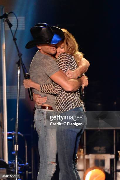 Tim McGraw and wife Faith Hill kiss onstage during the 2014 CMA Festival at LP Field on June 5, 2014 in Nashville, Tennessee.