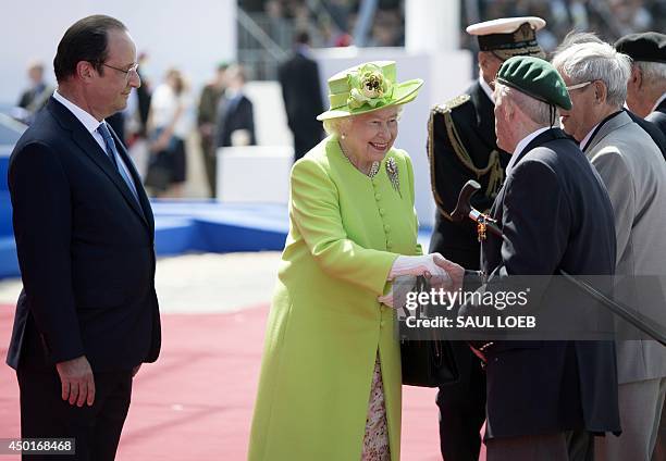 Britain's Queen Elizabeth II shakes hands with D-Day veterans alongside French President Francois Hollande during the Ouistreham International...