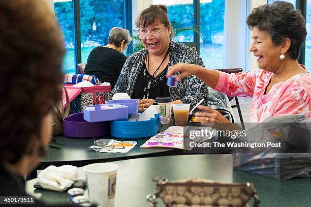 Tammy Patterson, center, and her mother, Rose Tompkins laugh with others at a weekly beading get-together where they say a lot of eating, gossiping...