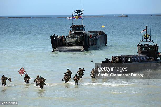 Re-enactors storm Gold Beach from a Royal Marine Landing craft during the 70th anniversary of the D-Day landings parade on June 6, 2014 in...