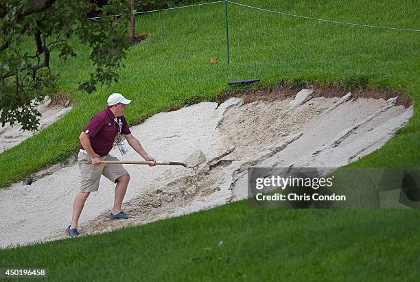 Volunteer repairs a bunker washed out by rain on the 3rd hole during the first round of the Big Cedar Lodge Legends of Golf presented by Bass Pro...