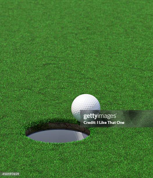 golf hole with a ball about to fall in - green de golf photos et images de collection