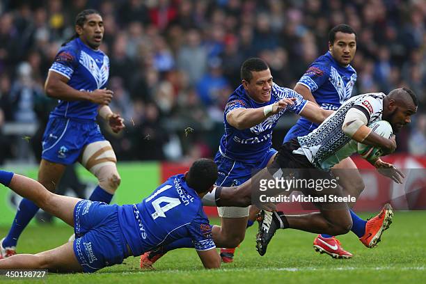 Marika Koroibete of Fiji is tackled by Michael Sio and Sauaso Sue of Samoa during the Rugby League World Cup Quarter Final match between Samoa and...