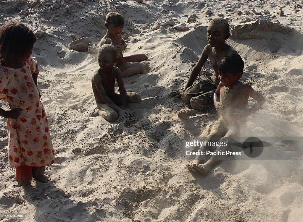 Pakistani children enjoy playing near a garbage dump site at...