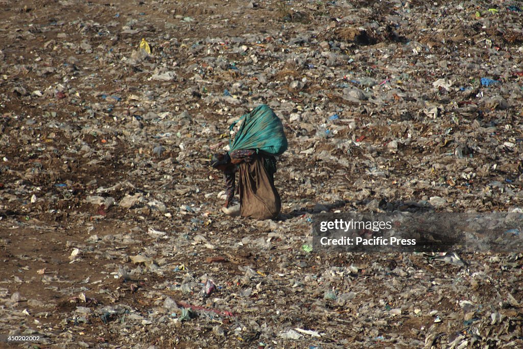 A Pakistani woman collects useful items from garbage a dump...