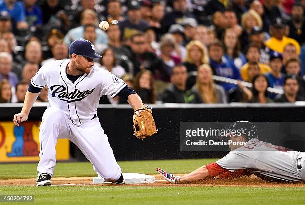 Danny Espinosa of the Washington Nationals slides into third base with a triple as Chase Headley of the San Diego Padres loses the ball during the...