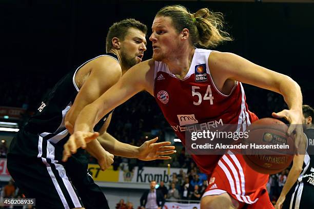 John Bryant of Muenchen is challenged by Robert Ohle of Tuebingen during the Beko Basketball Bundesliga match between FC Bayern Muenchen and WALTER...