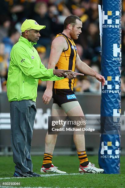 Jarryd Roughead of the Hawks walks past the goal umpire who signals a goal kicked by him during the round 12 AFL match between the Hawthorn Hawks and...