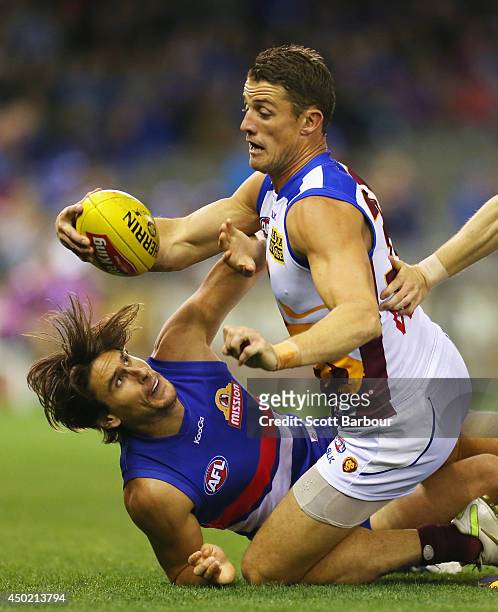 Matt Maguire of the Lions and Ryan Griffen of the Bulldogs compete for the ball during the round 12 AFL match between the Western Bulldogs and the...