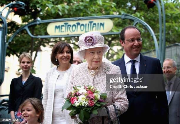 Anne Hidalgo Mayor of Paris and Francois Hollande President of France flank Queen Elizabeth II as she visits Paris Flower Market on June 7, 2014 in...