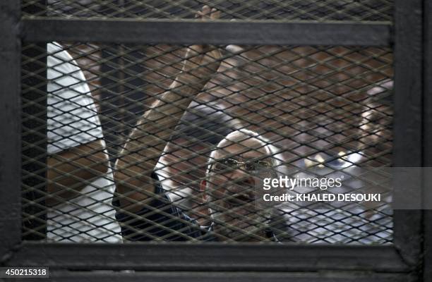 Egyptian Muslim Brotherhood leader Mohamed Badie gestures as he shouts from inside the defendants cage during his trial in the capital Cairo on June...