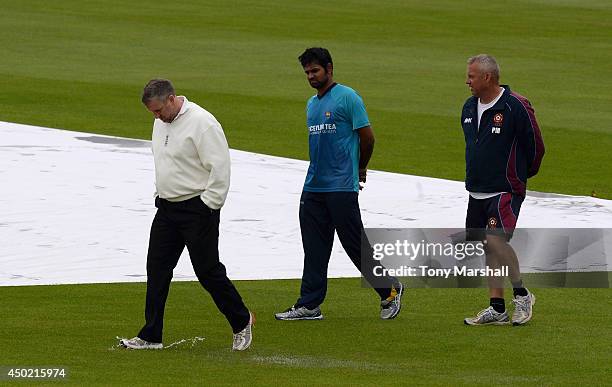 Lahiru Thirimanne of Sri Lanka with umpire Paul Pollard inspect the ground before the match is abandonned for the day due to flooding around the...