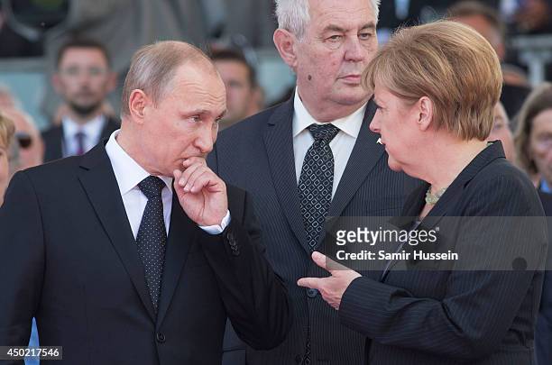 Russian President Vladimir Putin speaks to German Chancellor Angela Merkel as they attend a Ceremony to Commemorate D-Day 70 on Sword Beach during...