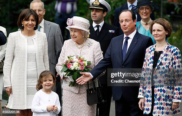 Queen Elizabeth II flanked by Anne Hidalgo Mayor of Paris and President of France Francois Hollande visits Paris Flower Market during a ceremony for...