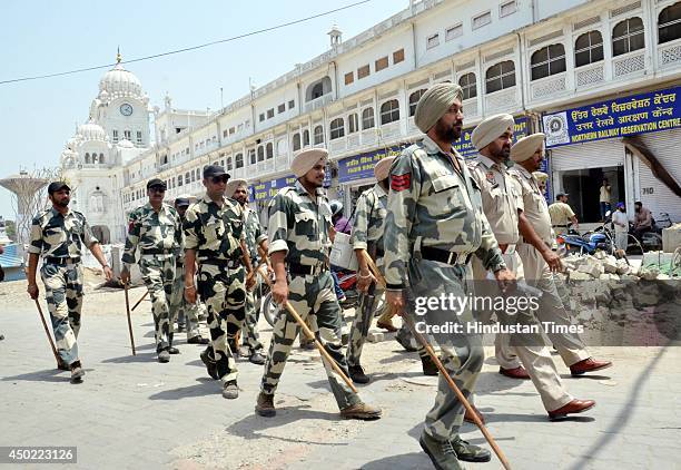 Security personnel march outside the Golden Temple, as violent clashes erupted between members of radical Sikh groups and the SGPC-run task force on...
