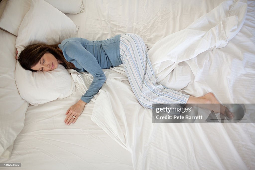 Middle aged woman sleeping in bed