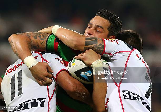 John Sutton of the Rabbitohs gets tackled by Jayson Bukuya and Shaun Johnson of the Warriors during the round 13 NRL match between the South Sydney...