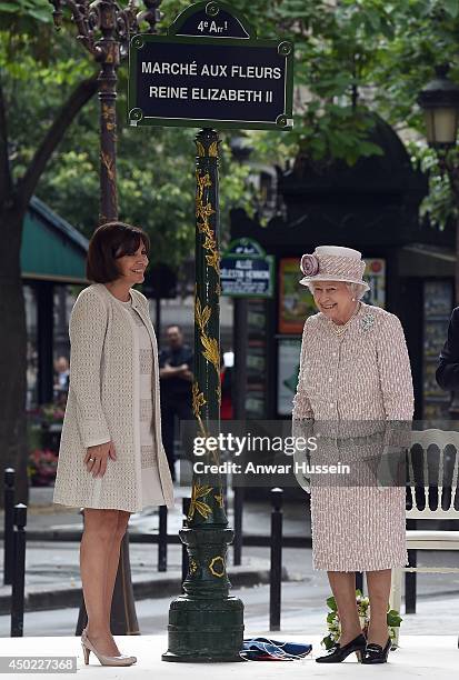 Queen Elizabeth ll, watched by the Mayor of Paris Anne Hidalgo, unveils a sign to rename the Marche aux Fleurs et aux Oiseaux the' Marche aux Fleurs...