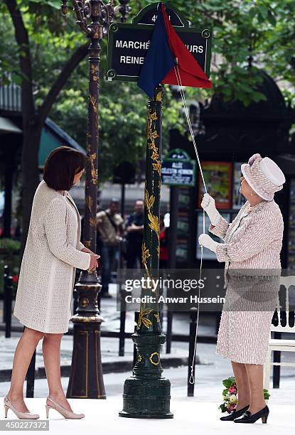 Queen Elizabeth ll, helped by the Mayor of Paris Anne Hidalgo, unveils a sign to rename the Marche aux Fleurs et aux Oiseaux the' Marche aux Fleurs...