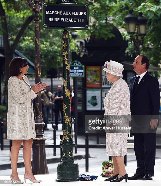 Queen Elizabeth ll, watched by the Mayor of Paris Anne Hidalgo and French President Francois Hollande, unveils a sign to rename the Marche aux Fleurs...