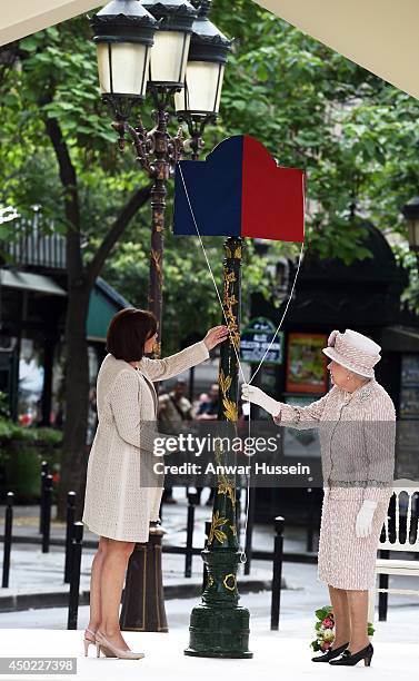 Queen Elizabeth ll, helped by the Mayor of Paris Anne Hidalgo, unveils a sign to rename the Marche aux Fleurs et aux Oiseaux the' Marche aux Fleurs...
