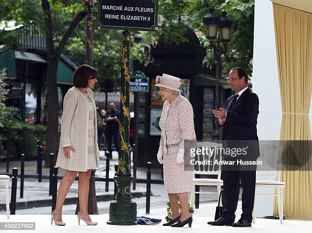 Queen Elizabeth ll, watched by the Mayor of Paris Anne Hidalgo and French President Francois Hollande, unveils a sign to rename the Marche aux Fleurs...