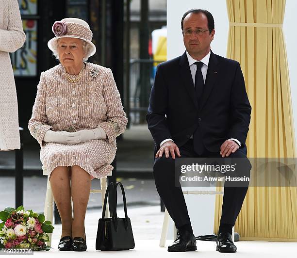 Queen Elizabeth ll and French President Francois Hollande sit together as they listen to a speech during a visit to the Marche aux Fleurs et aux...