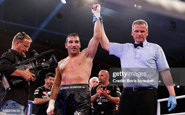 The ring referee lifts the arm of winner Firat Arslan of Germany after his cruiserweight fight against Tamas Bajzath of Hungary at Sport- und...