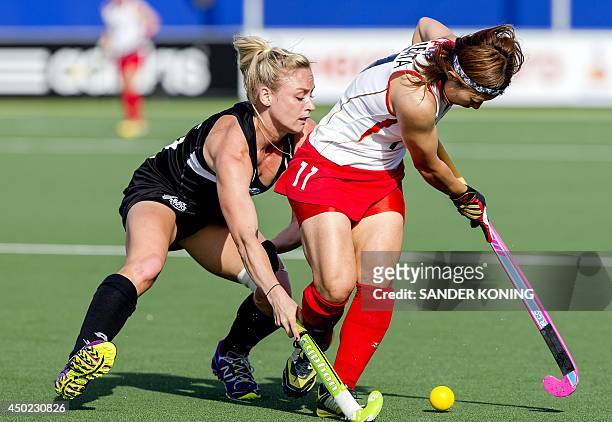 Japan's Akane Shibata fights for the ball with New Zealand's Stacey Michelsen during a stage match in the women's tournament of the Field Hockey...