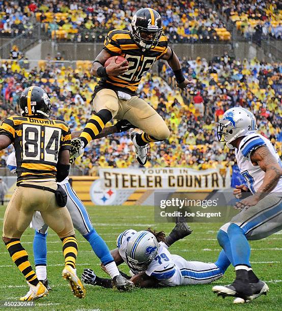 Le'Veon Bell of the Pittsburgh Steelers jumps to avoid a tackle by Willie Young of the Detroit Lions on November 17, 2013 at Heinz Field in...